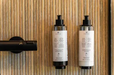 two bottles of sunscreen on a wooden wall at Chill Hill Kalviai in Kalviai