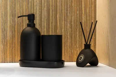 a black soap dispenser next to a vase with sticks at Chill Hill Kalviai in Kalviai