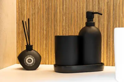 a black soap dispenser and a bottle on a table at Chill Hill Kalviai in Kalviai