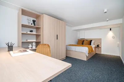 a bedroom with a bed and a desk with a table at We LOFT in Vilnius