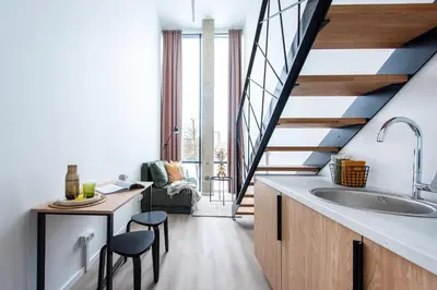 a kitchen with a large sink and a staircase at We LOFT in Vilnius