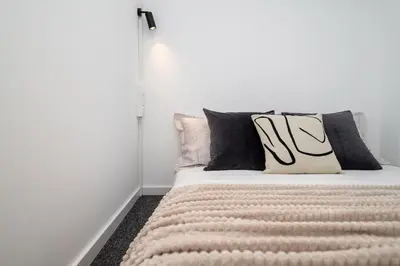 a bed with black and white pillows on it at We LOFT in Vilnius