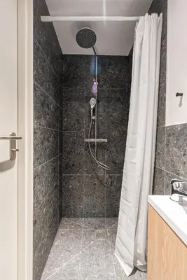 a bathroom with a shower with a shower curtain at We LOFT in Vilnius