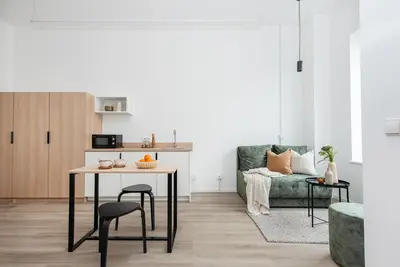 a living room with a table and a green couch at We LOFT in Vilnius