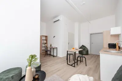 a kitchen and a living room with a table and chairs at We LOFT in Vilnius