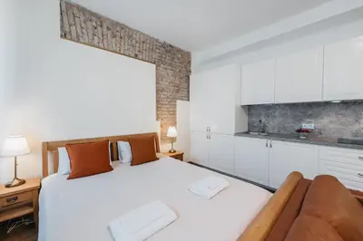 a bedroom with a large white bed and a couch at CATHEDRAL Old Town Suites in Vilnius