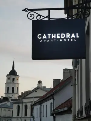 a sign for a cathetical apartment hotel in front of a building at CATHEDRAL Old Town Suites in Vilnius