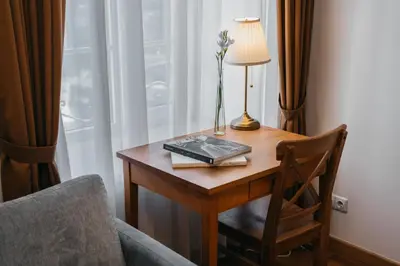 a table with a lamp and a vase of flowers on it at CATHEDRAL Old Town Suites in Vilnius