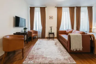a living room with a couch and a table and a television at CATHEDRAL Old Town Suites in Vilnius