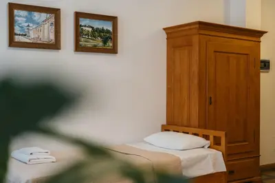a bedroom with two beds and a wooden cabinet at CATHEDRAL Old Town Suites in Vilnius