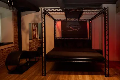a black bed in a room with a wall at BDSM Black Apartments in Vilnius