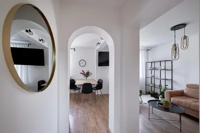 a living room with a mirror and a couch at Resort Stories Išskirtiniai 7 vietų apartamentai Birštone in Birštonas