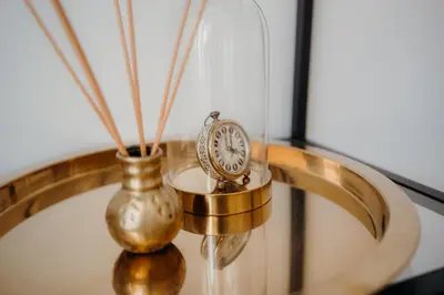 a table with a clock and a vase on it at Resort Stories Išskirtiniai 7 vietų apartamentai Birštone in Birštonas
