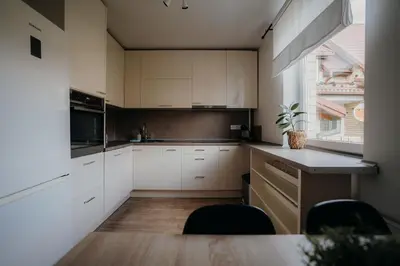 a kitchen with white cabinets and a table and chairs at Resort Stories Išskirtiniai 7 vietų apartamentai Birštone in Birštonas
