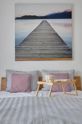 a wooden pier over the water with a table at Resort Stories Išskirtiniai 7 vietų apartamentai Birštone in Birštonas