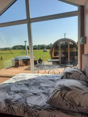 a bed in a room with a large window at Vipoilsis Namelis N1 in Čekoniškės