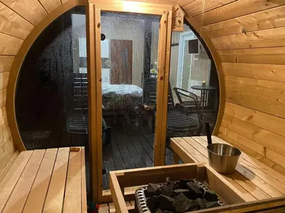 a outside view of a wooden cabin with a patio at Vipoilsis Namelis N1 in Čekoniškės