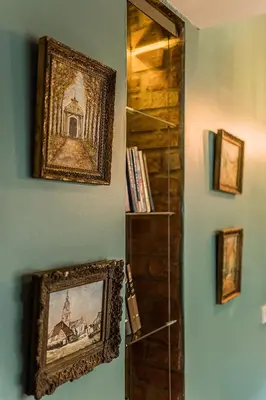 a wall with a picture and a shelf with books at Quiet and Cosy apartment in Kaunas Old Town in Kaunas