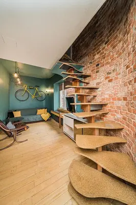 a living room with a brick wall and wooden stairs at Quiet and Cosy apartment in Kaunas Old Town in Kaunas