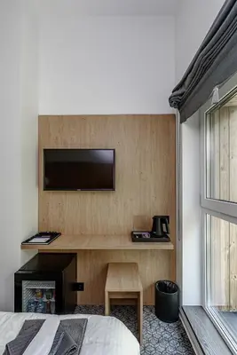 a bedroom with a desk with a television on a wall at Molėtairesort in Molėtai