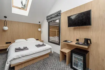 a bedroom with a bed and a fireplace and a tv at Molėtairesort in Molėtai