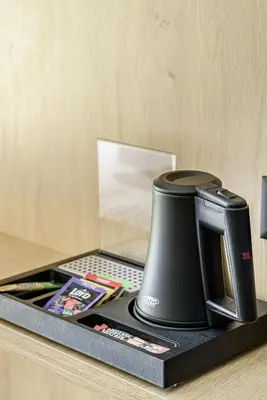 a black coffee maker sitting on top of a counter at Molėtairesort in Molėtai