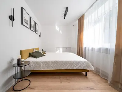 a white bedroom with a bed and a window at Modern 2 bedroom Vytenio apartment in city centre I Self check-in in Vilnius