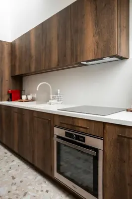 a kitchen with wooden cabinets and a stove top oven at Loft 27 in Kaunas