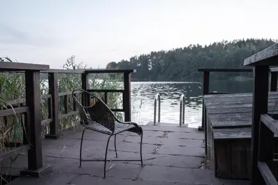 a chair sitting on a dock near a body of water at Ivanas Countryside in Bražuolė