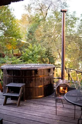 a wooden deck with a hot tub and a table at Ivanas Countryside in Bražuolė