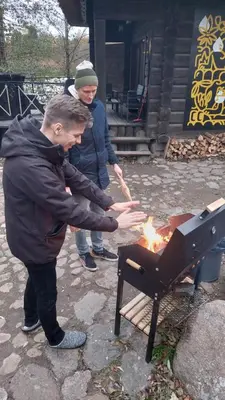 a man and a woman cooking over a grill at Ivanas Countryside in Bražuolė
