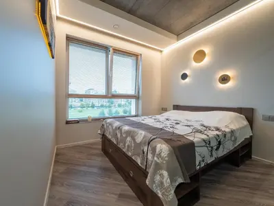 a bedroom with a bed and a large window at Cozy Apartment Vilnius in Vilnius