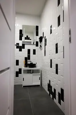 a bathroom with black and white tile on the wall at Romantic Room Šiauliai in Šiauliai