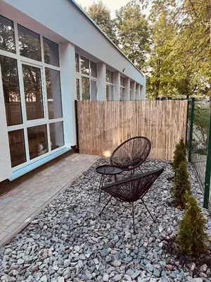 a patio with a chair and a table on a rock at Romantic Room Šiauliai in Šiauliai
