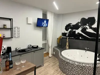 a bathroom with a tub and a sink and a tv at Romantic Room Šiauliai in Šiauliai