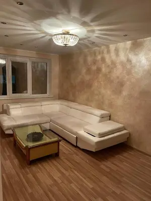 a living room with a white couch and a table at Dainai Apartments in Šiauliai