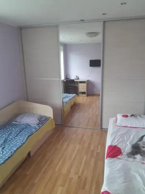 a room with two beds and a mirror at Dainai Apartments in Šiauliai