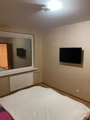 a bedroom with a bed and a flat screen tv at Dainai Apartments in Šiauliai