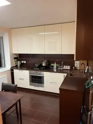 a kitchen with white cabinets and a stove top oven at Dainai Apartments in Šiauliai