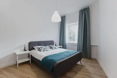 a bedroom with a bed with a blue blanket at Vilnius Old Town Apt Subacius 3. Free Parking in Vilnius
