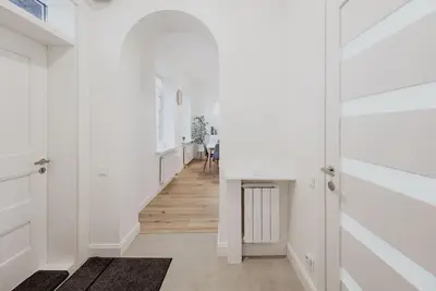a hallway with white walls and a white hallway with wooden floors at Vilnius Old Town Apt Subacius 3. Free Parking in Vilnius