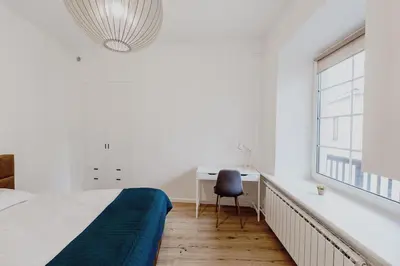 a bedroom with a bed and a desk and a window at Vilnius Old Town Apt Subacius 3. Free Parking in Vilnius