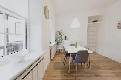 a white kitchen with a table and chairs at Vilnius Old Town Apt Subacius 3. Free Parking in Vilnius