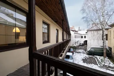 a balcony of a house with a car in the snow at Vilnius Old Town Apt Subacius 3. Free Parking in Vilnius