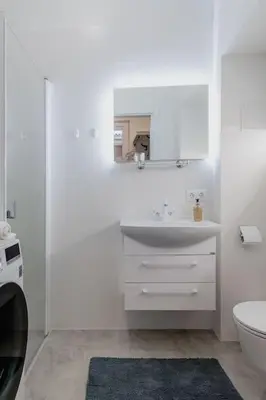 a white bathroom with a sink and a toilet at Vilnius Old Town Apt Subacius 3. Free Parking in Vilnius