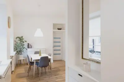 a white dining room with a white table and chairs at Vilnius Old Town Apt Subacius 3. Free Parking in Vilnius