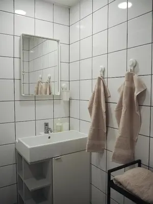 a white bathroom with a sink and a mirror at Cozy city center apartment in Visaginas