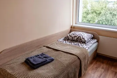 a bed sitting in a room with a window at Studio Apartment in Kaunas