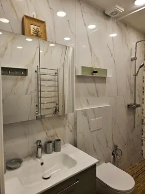a bathroom with a sink and a toilet and a mirror at Uzupis Riverside Apartment in Vilnius