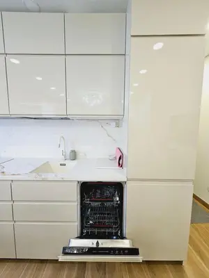 a white kitchen with an open oven in the middle at Uzupis Riverside Apartment in Vilnius